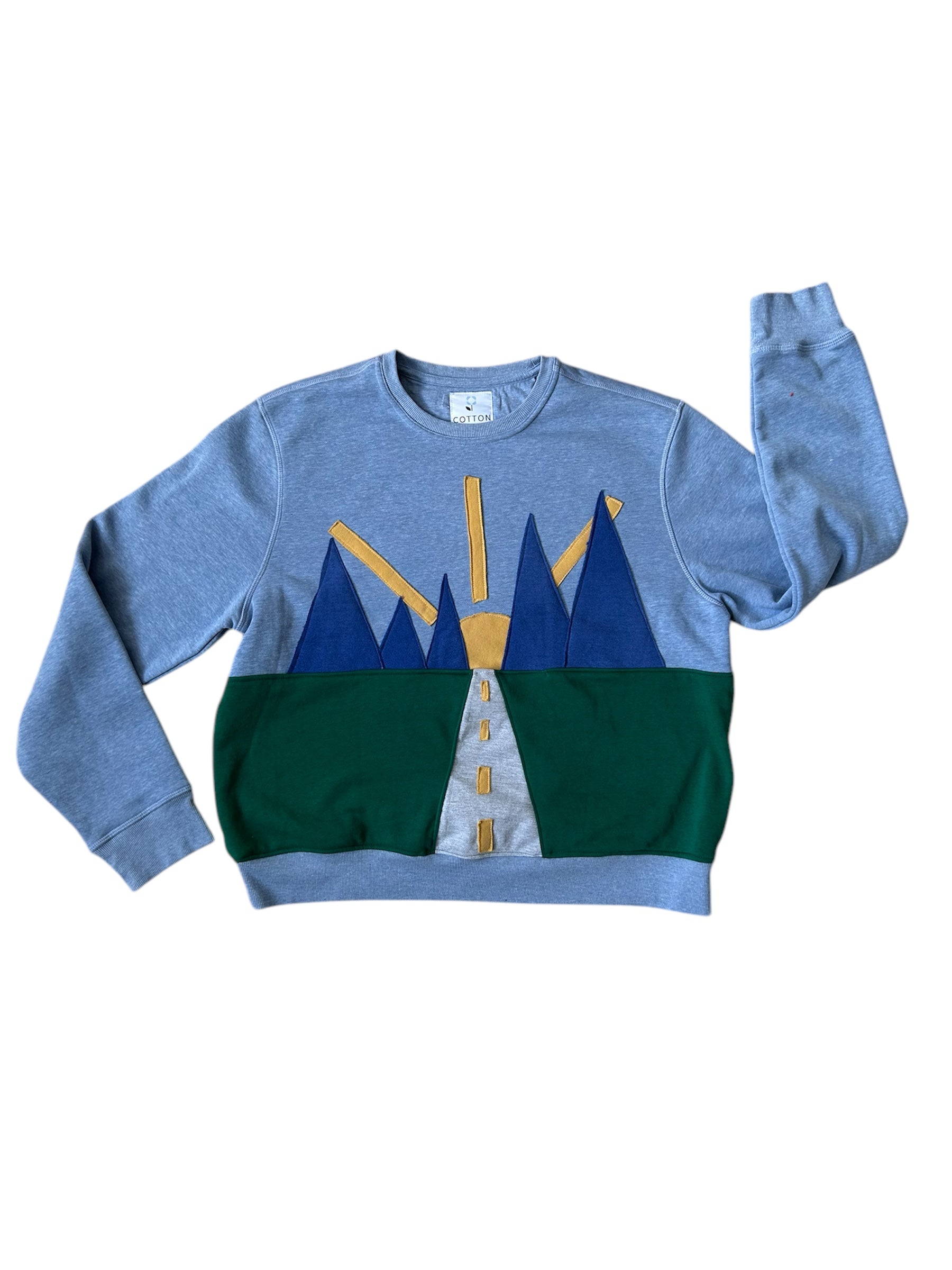 A sweatshirt with a graphic design resembling a mountain range in blue, green, and yellow colors on the front, with a Nike logo on the upper left.