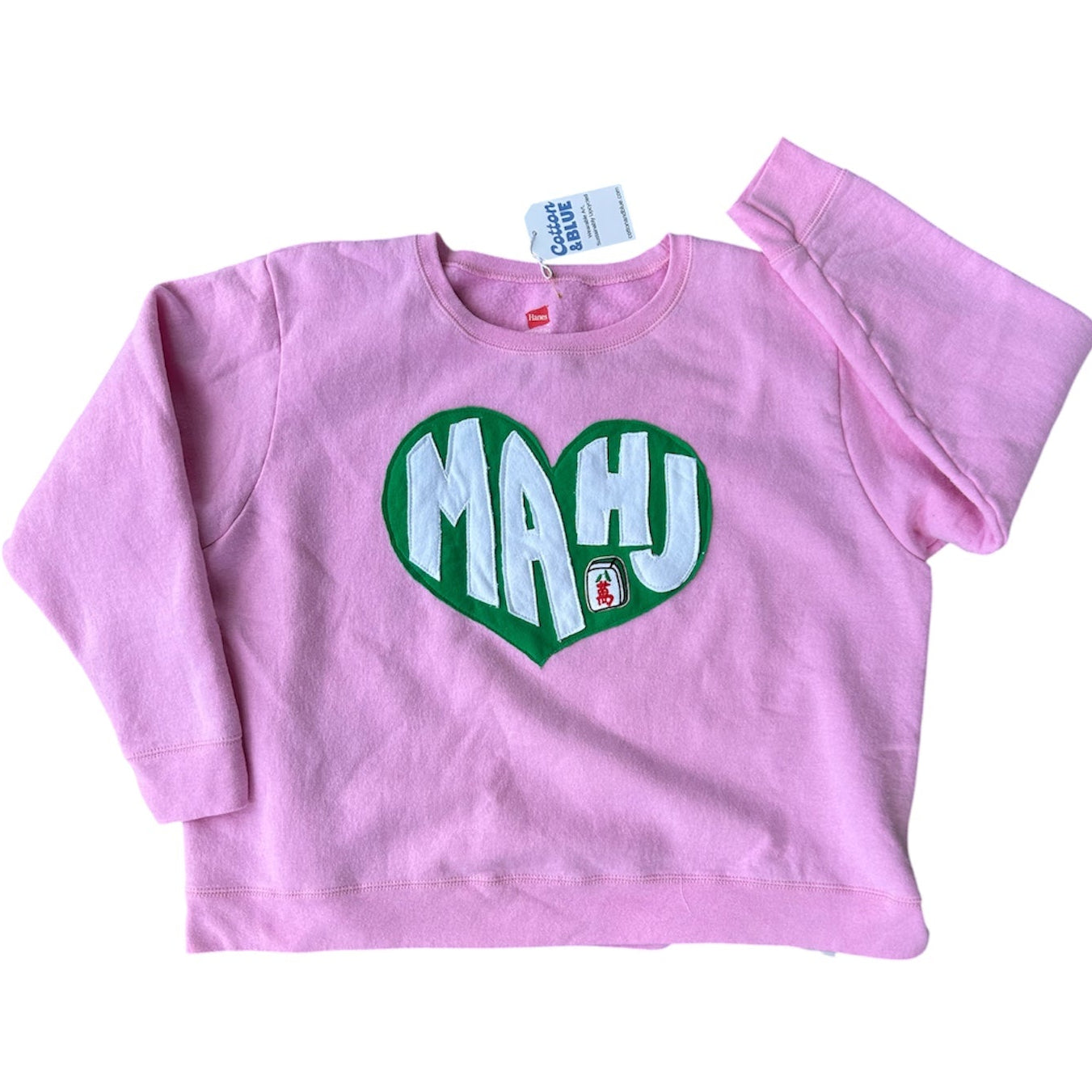 Pink sweatshirt with green heart-shaped text on a white background
