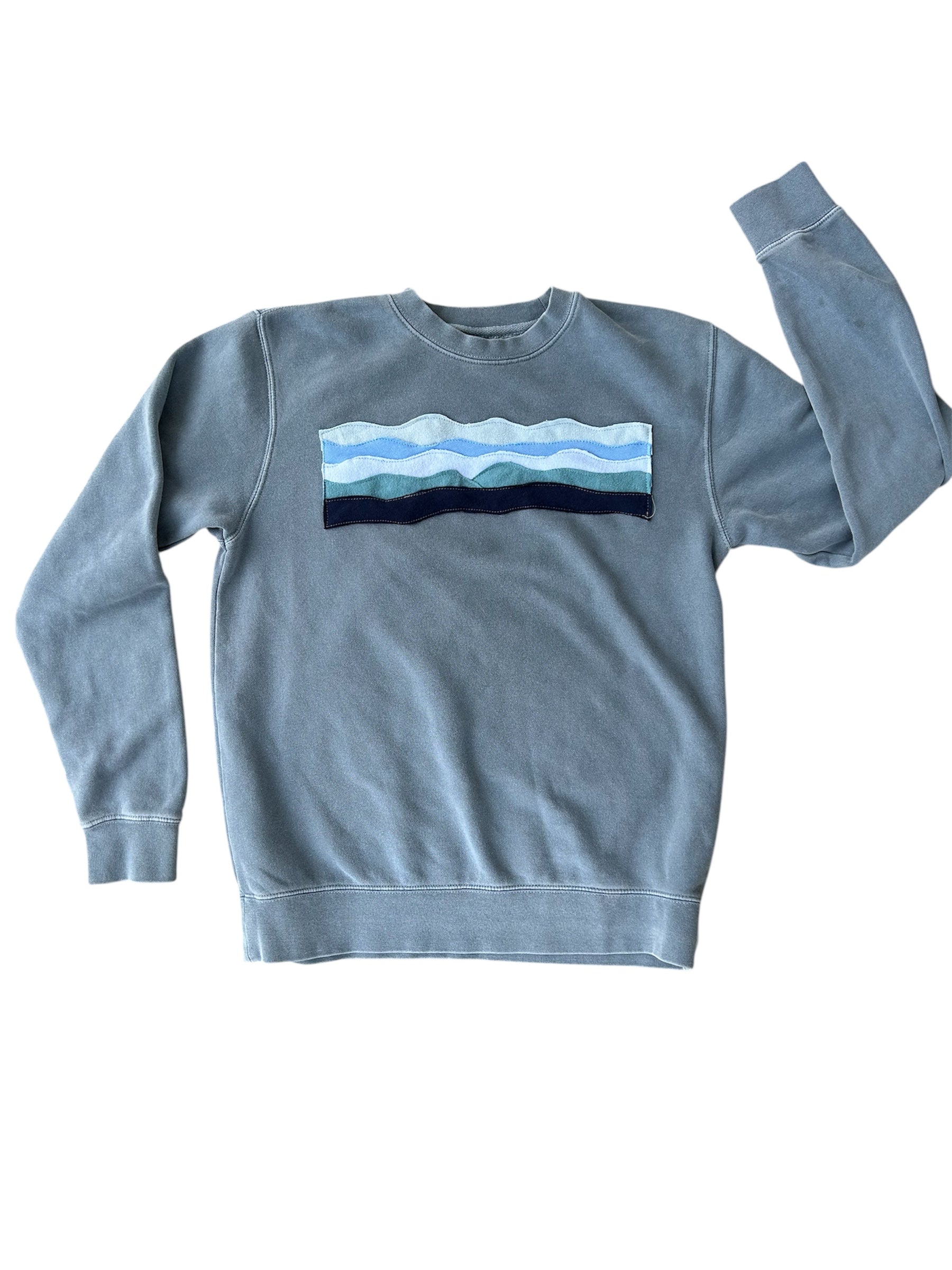Light blue sweatshirt with a mountain design on a white background